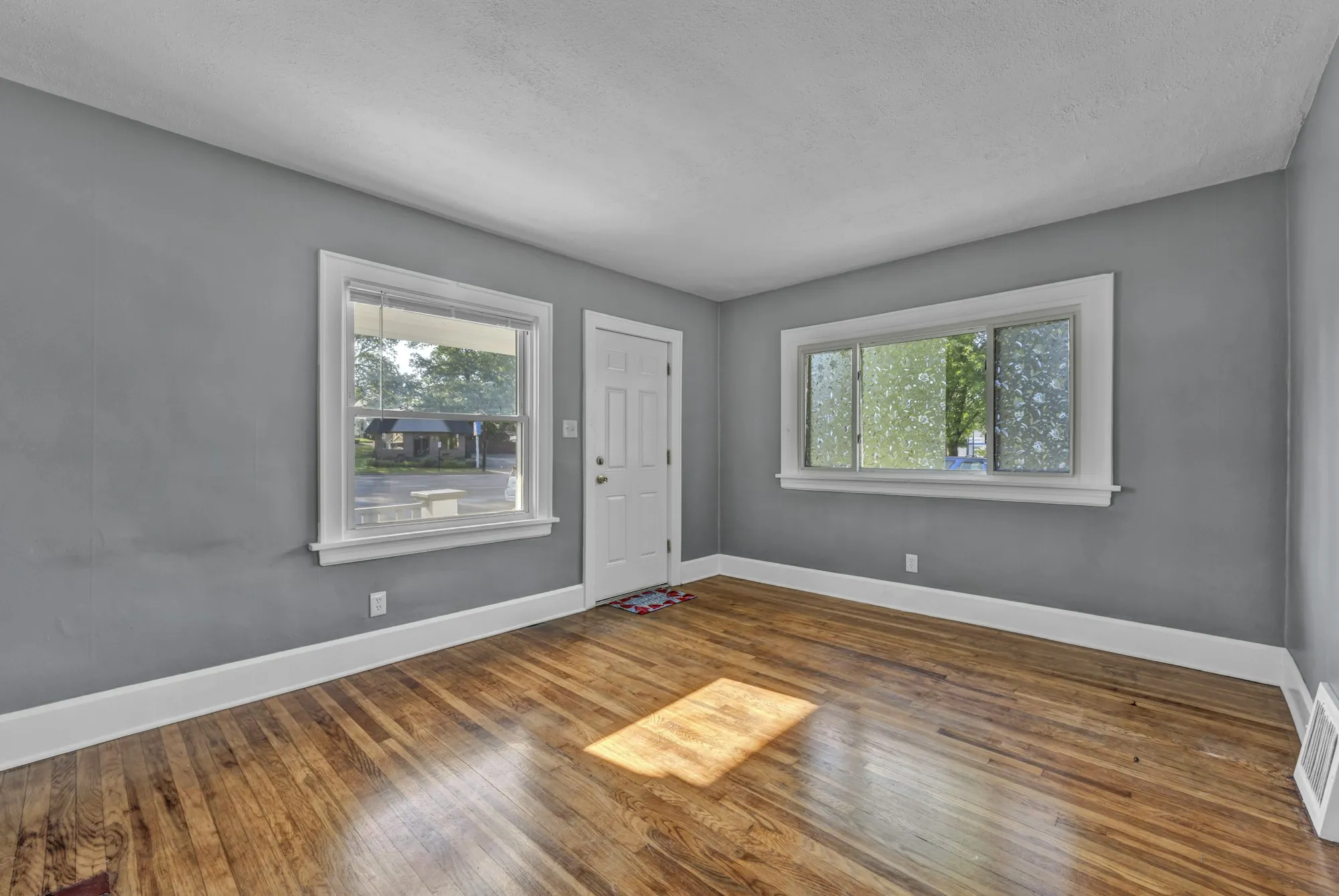 Empty room with freshly painted walls and wood floors