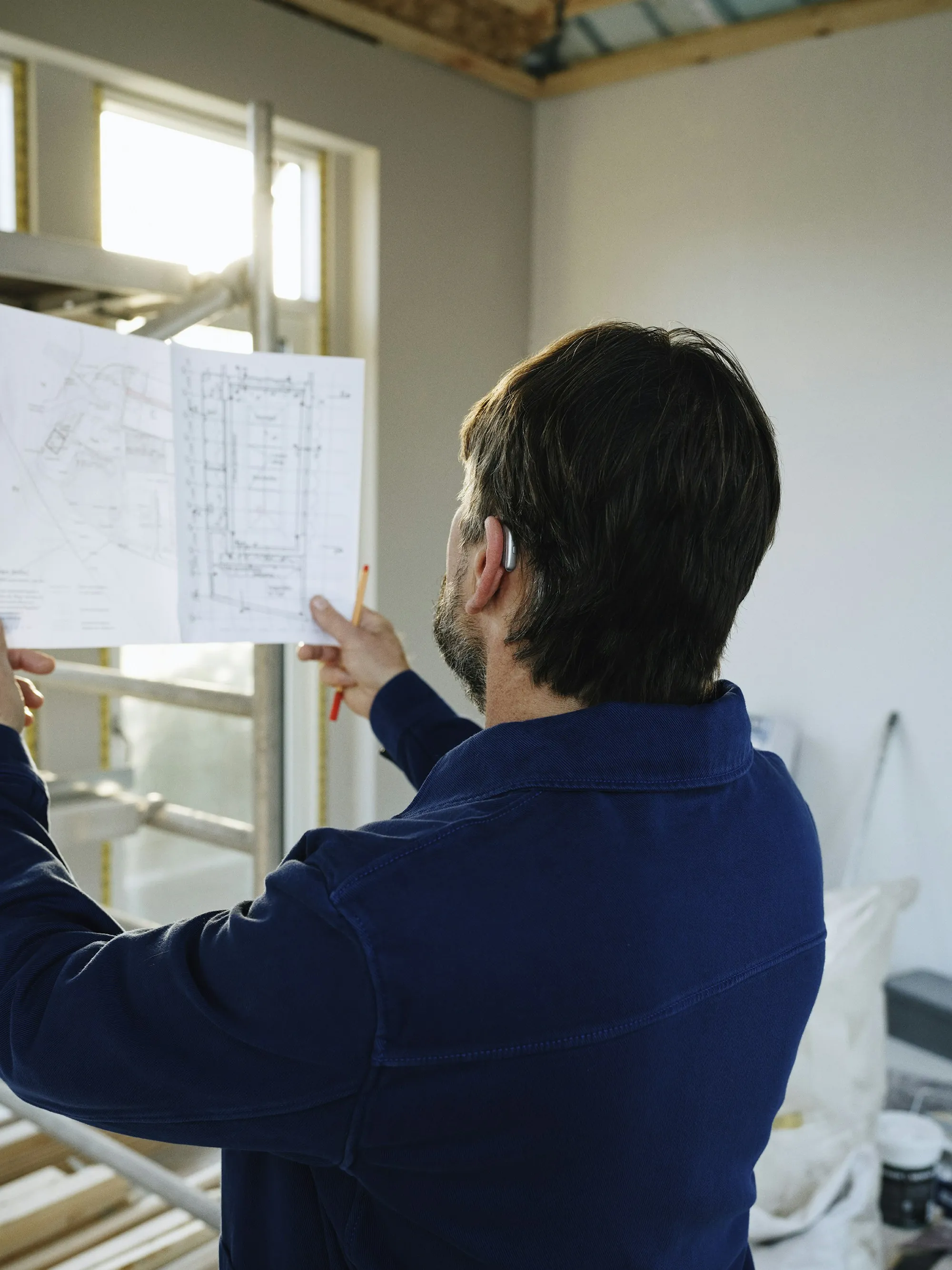 Reviewing remodel plans in a room being renovated
